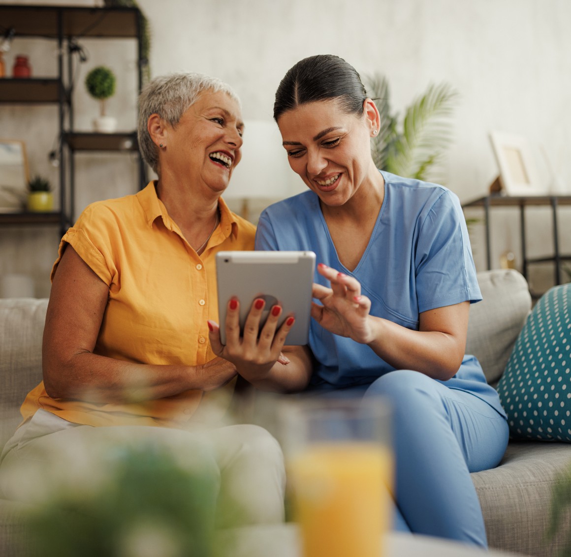 Caregiver and senior woman looking at tablet together – Private Pay Caregiver and senior woman looking at tablet together - Private Pay